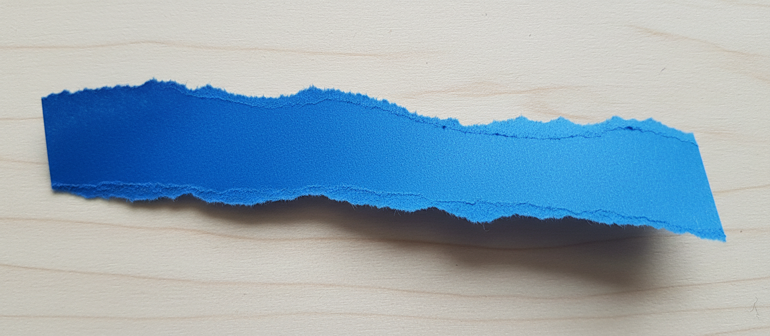 들쭉날쭉한 모서리의 손으로 찢은 파란색 건축 종이 질감.