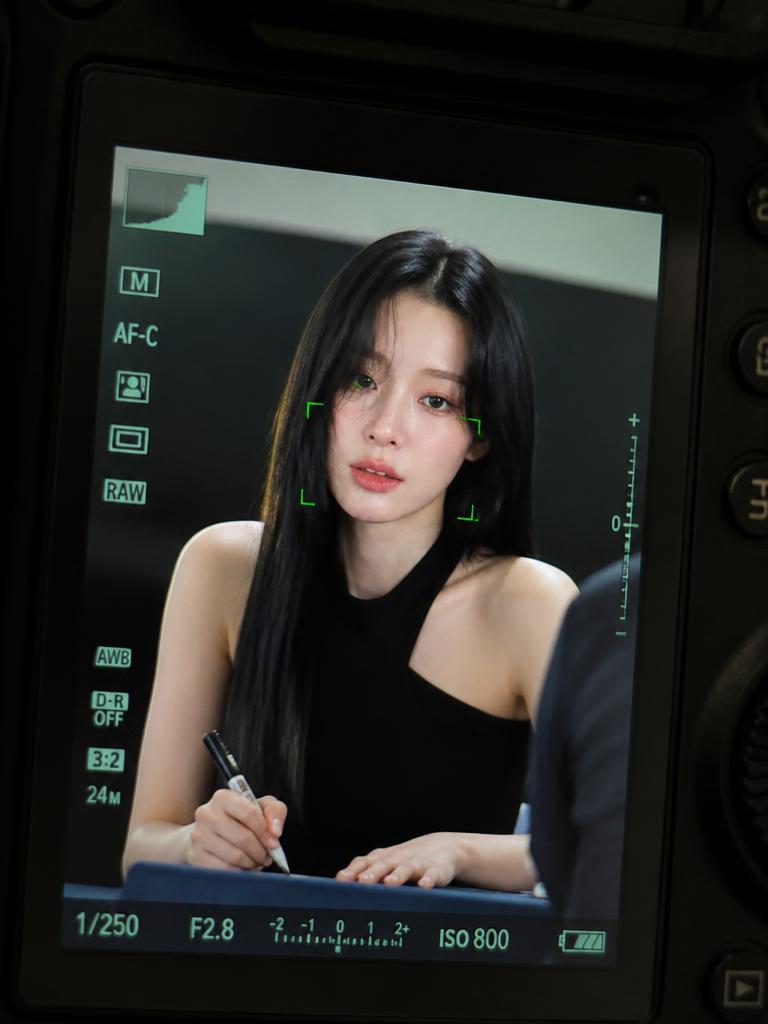 A realistic K-pop fansign portrait framed inside a DSLR camera LCD screen with autofocus overlays.