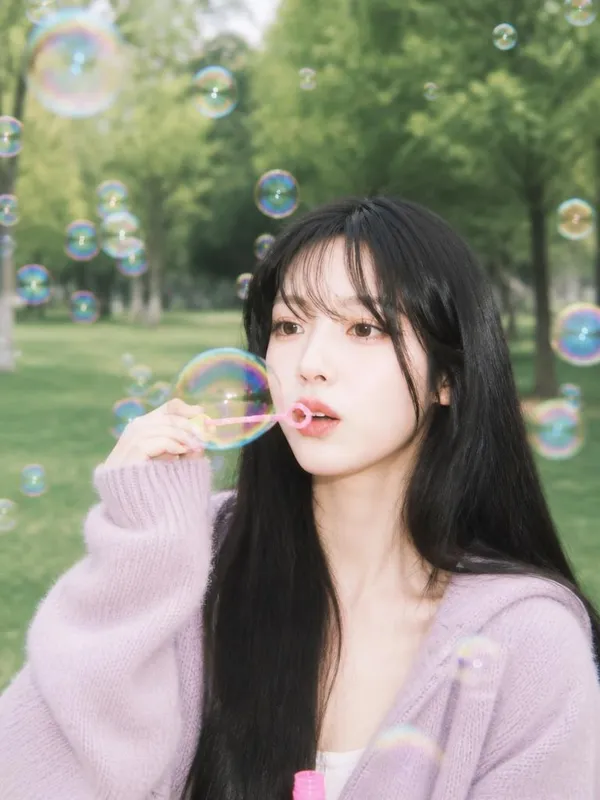 A whimsical park portrait with a bubble wand and iridescent soap bubbles floating around the face.