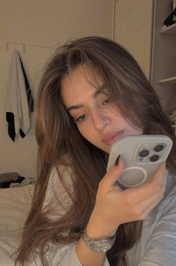AI-generated Realistic Young Woman Sitting Casually in a Softly Lit Bedroom During Late Afternoon made with GPT Image 2
